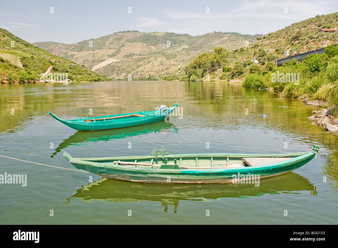 Two Boats moored in calm water on the River Duero in Portugal Stock Photo