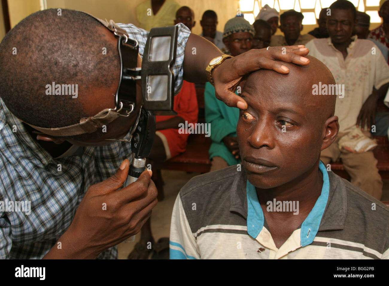 Men waiting for an eye test in a clinic in Sierra Leone, West Africa Stock Photo