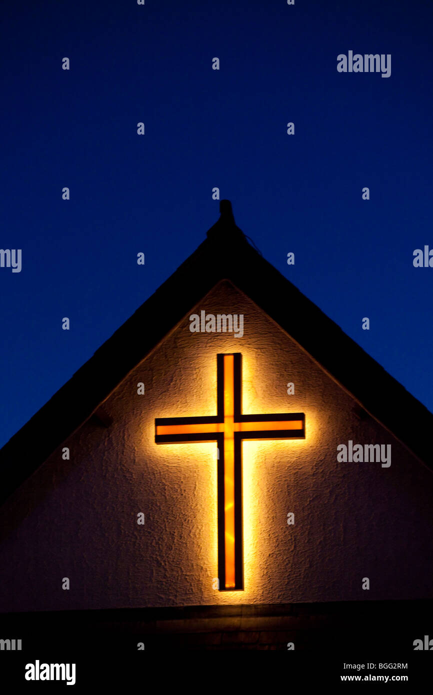 Illuminated cross on gable end of a church hall Kent UK Stock Photo