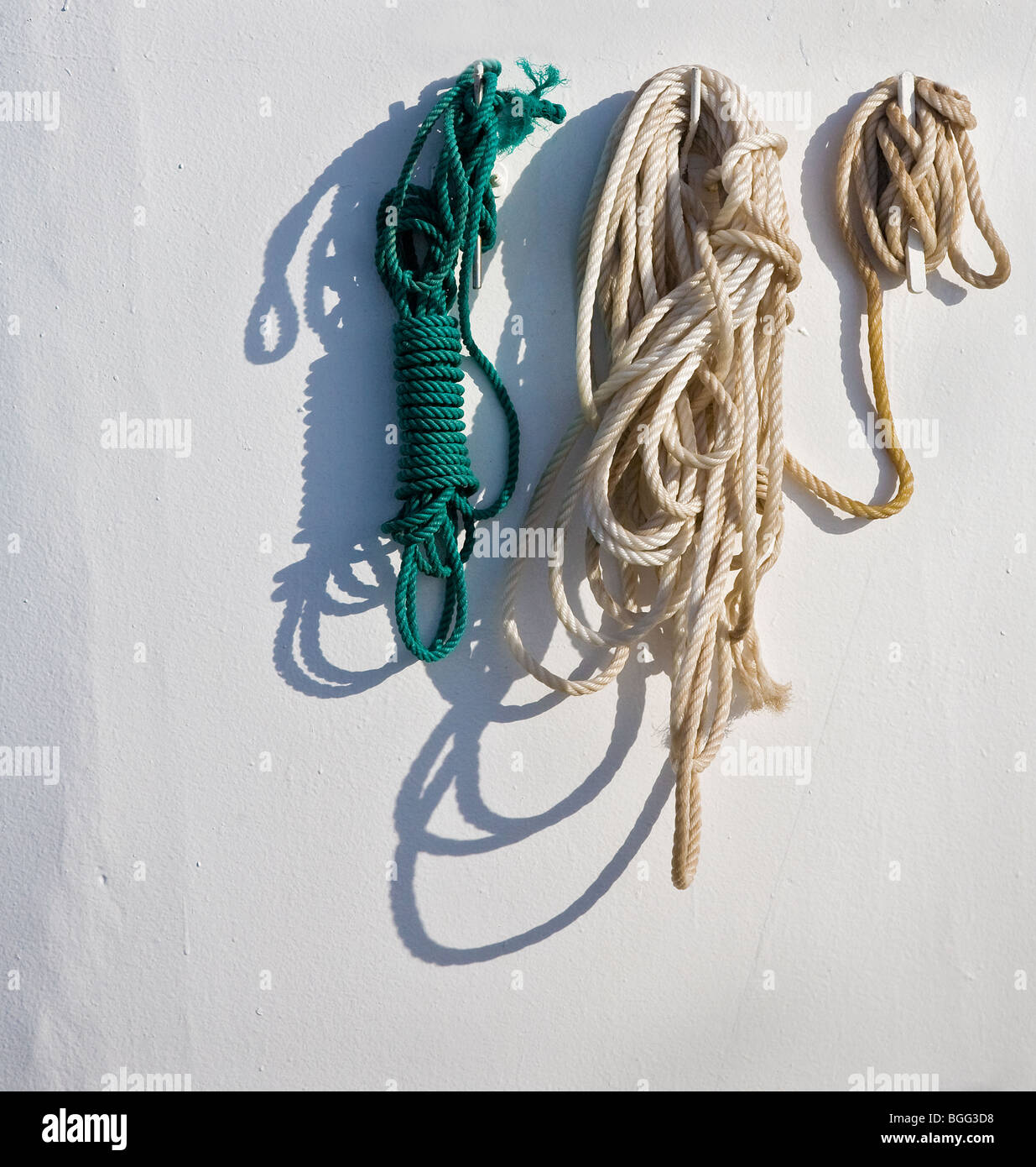 Rope ( and shadow ) hanging from hooks on a ship's funnel Stock