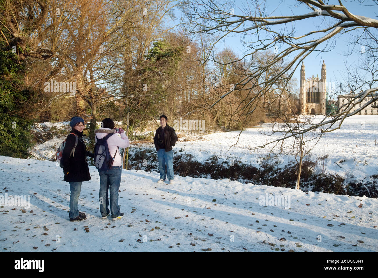 Tourists taking photos on the backs in winter, Kings College chapel in the background, Cambridge, UK Stock Photo