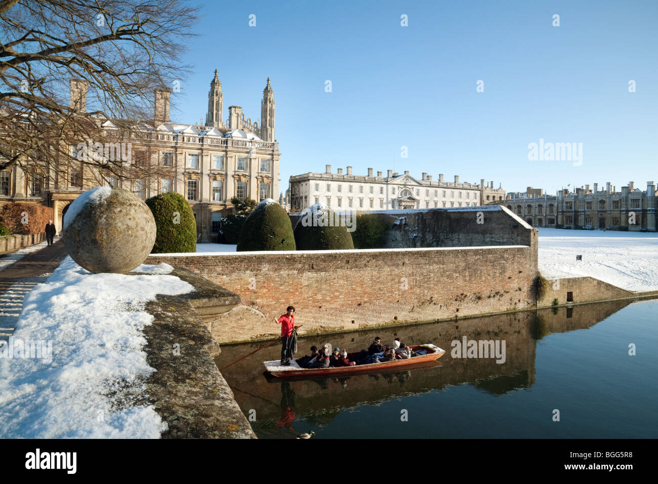 A lone punt with tourists having a guided tour on the river Cam in midwinter, Clare and Kings Colleges, Cambridge University, UK Stock Photo