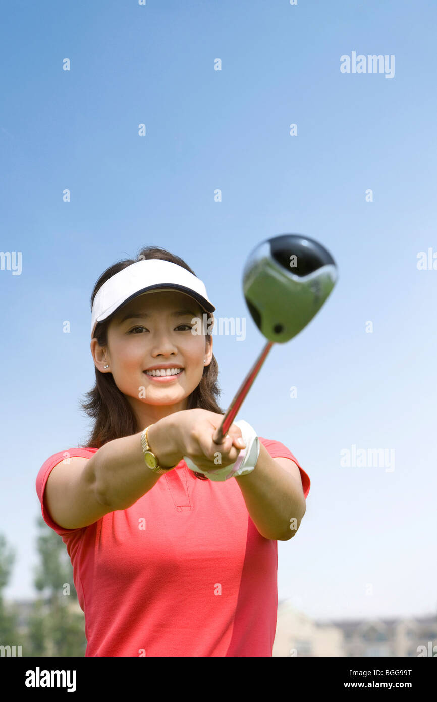 Portrait of a smiling female Golfer, club in hand Stock Photo