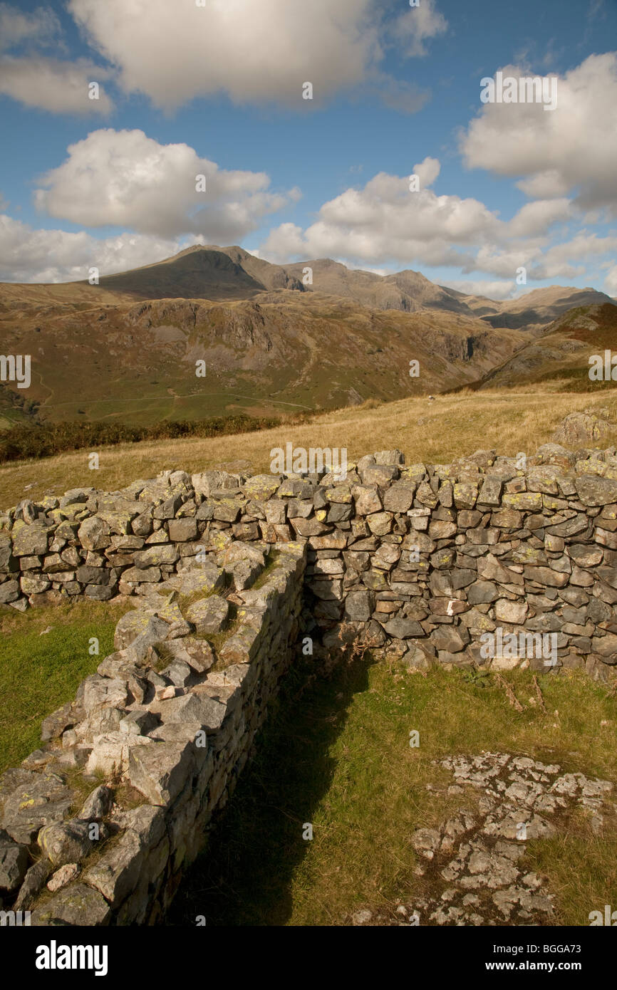 Scafell Pike and the Scafell mountain range in the english lake district seen from the remains of Hardknott Roman Castle Stock Photo