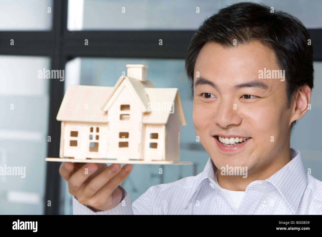 Young man holding a house model Stock Photo - Alamy
