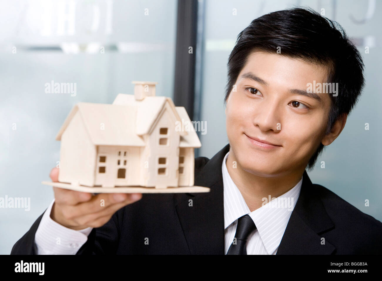 Young man holding a house model Stock Photo - Alamy