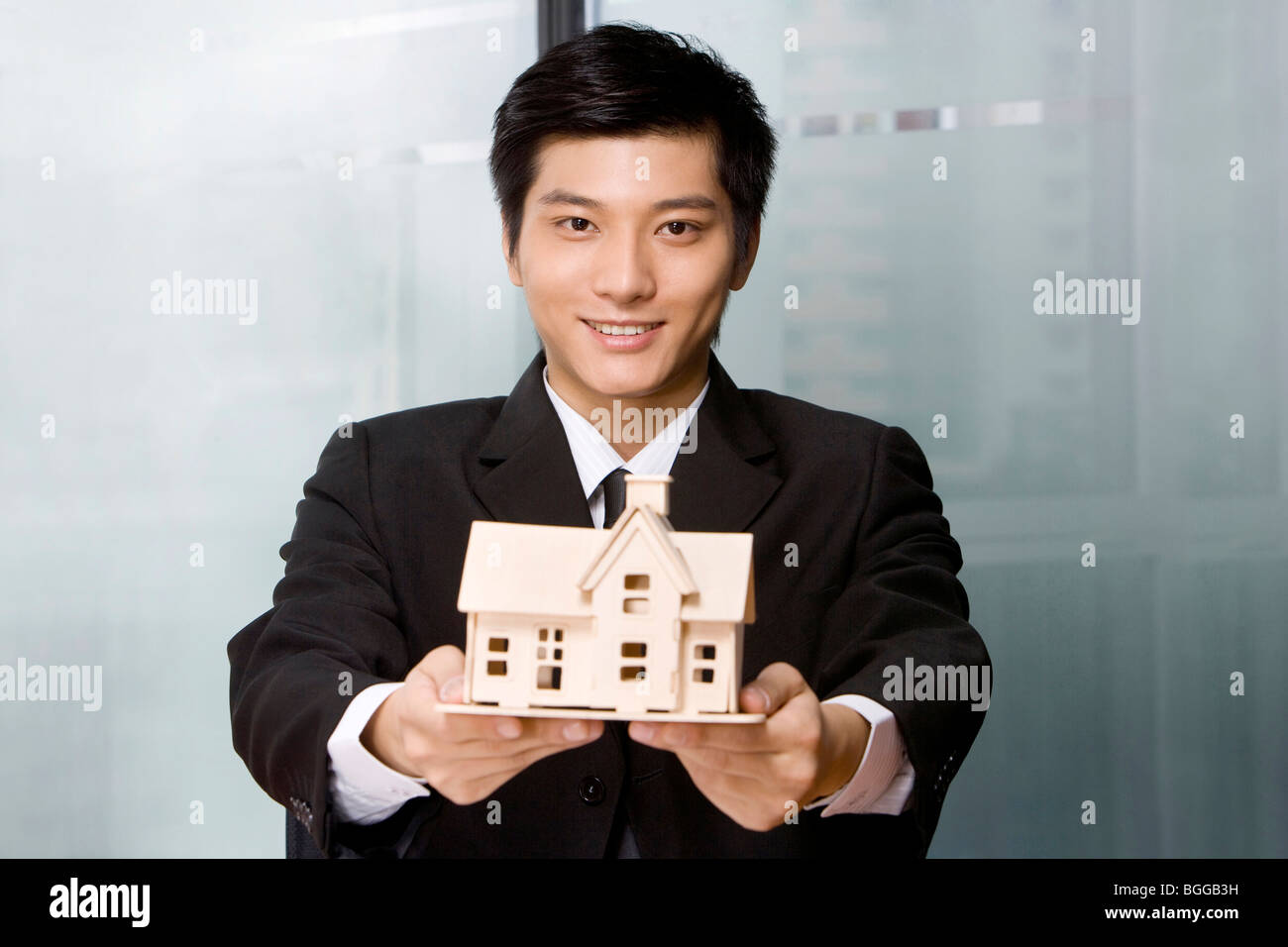 Young man holding a house model Stock Photo - Alamy