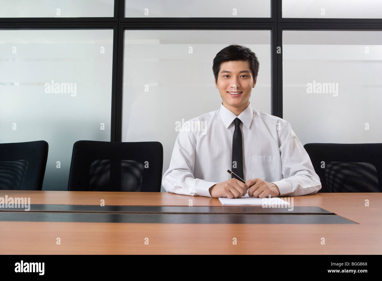 Young businessman sitting in meeting room Stock Photo Alamy