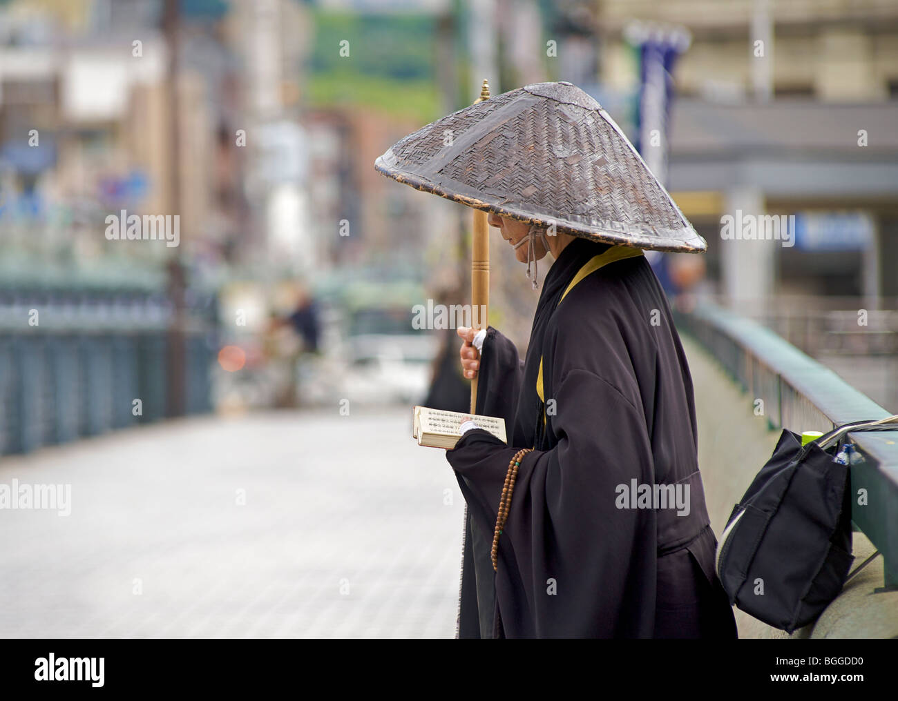 Japanese wandering monk offering prayer on a bridge to Gion, Kyoto, Japan Stock Photo