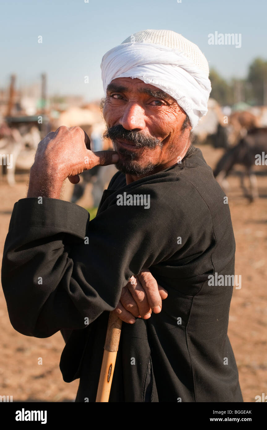 Turbaned Egyptian man with full mustache and cane in a camel market along the Nile. Stock Photo