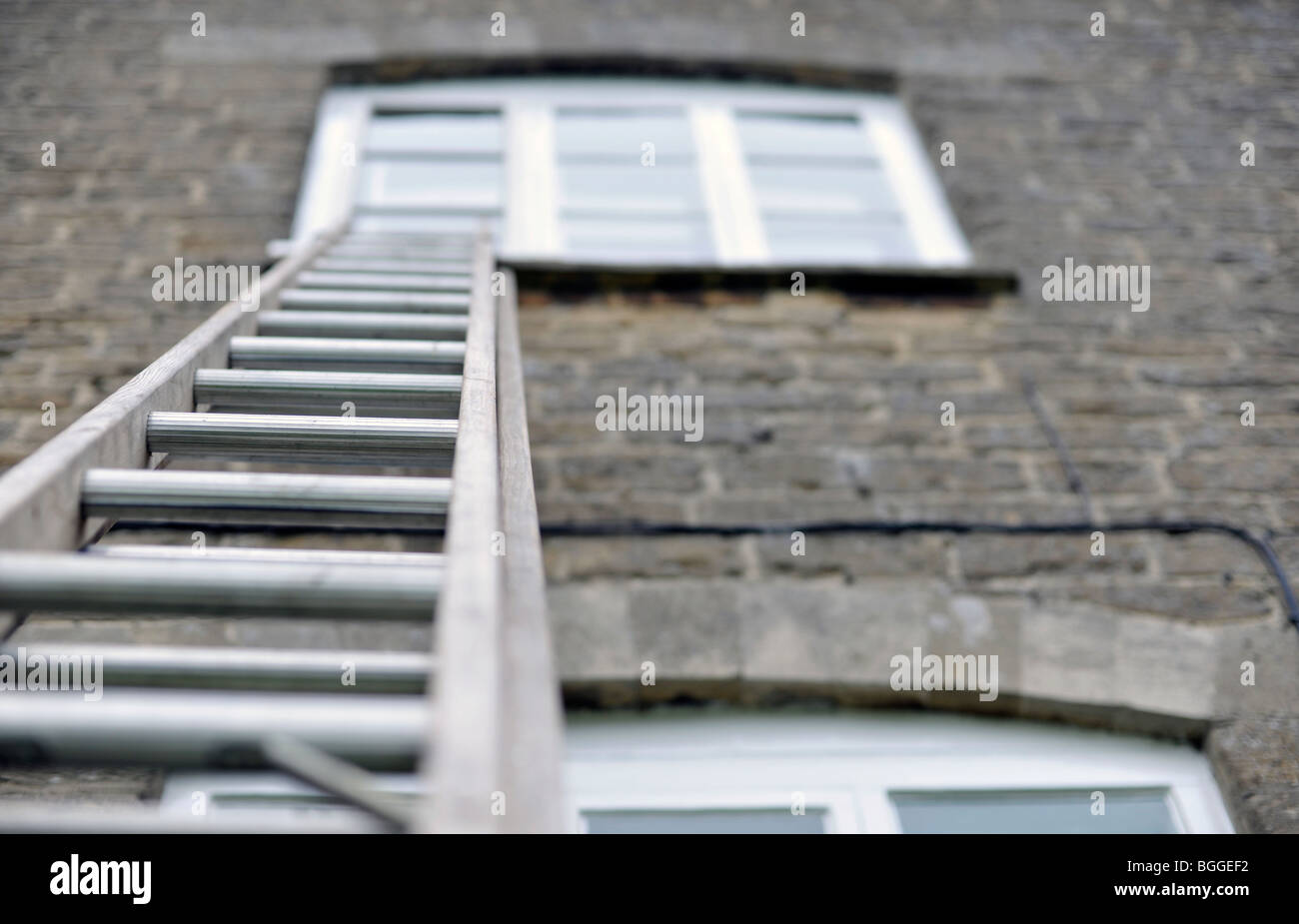 ladder reaching up to window Stock Photo