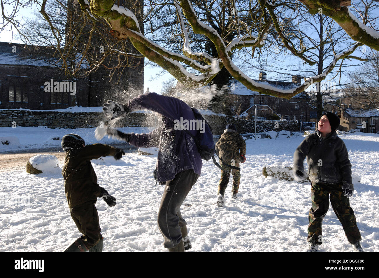 Children and adult having a snowball fight in the village of Widecome in the Moor Devon England Stock Photo