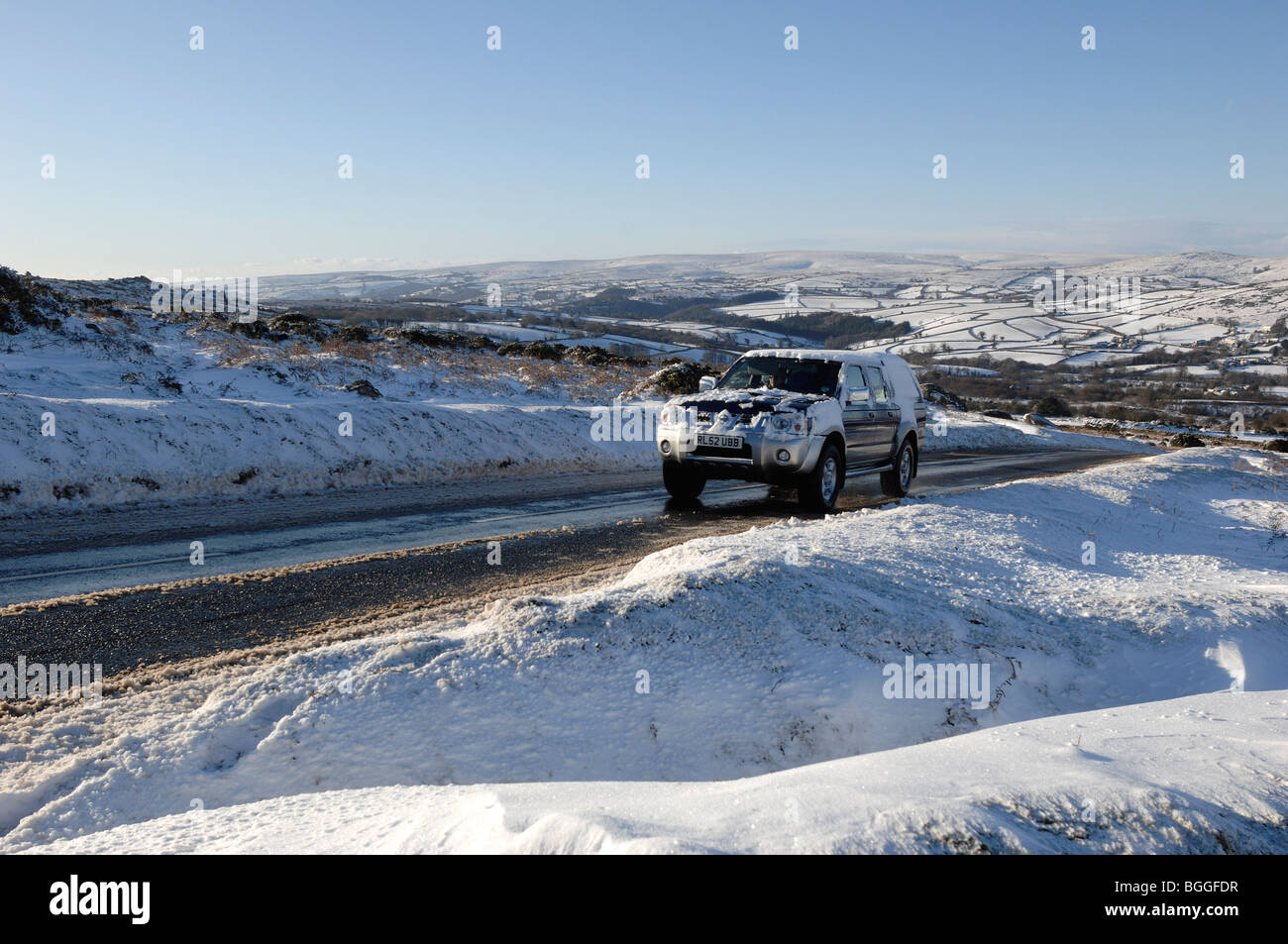 Four wheel drive vehicle on Snow covered road out of Widecombe in the Moor Dartmoor Devon England Stock Photo
