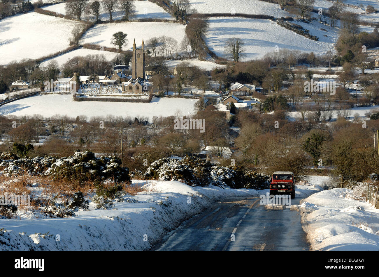 Four wheel drive vehicle on snow covered road leading our of Widecombe in the Moor village dartmoor devon Stock Photo