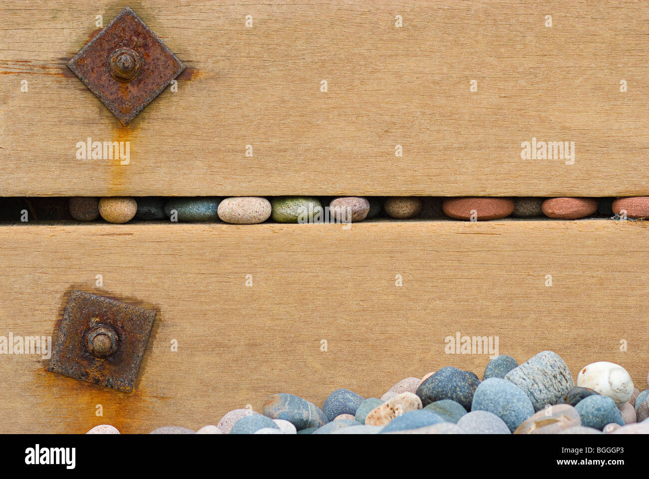 Smooth pebbles trapped in the gaps of wooden groins or sea defences make artistic compositions Stock Photo