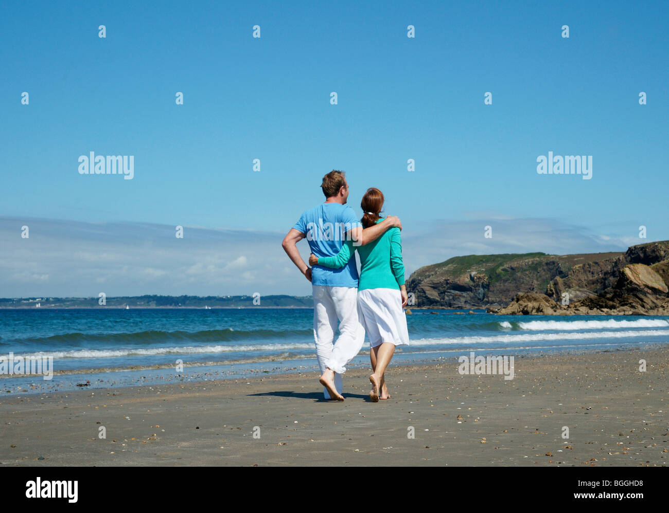 Couple walking along the beach, rear view Stock Photo