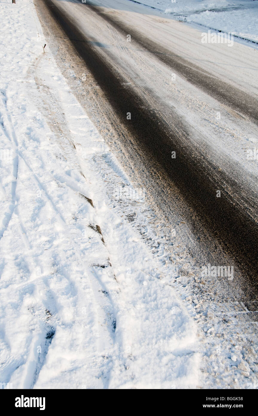 Tyre tracks on an empty road covered in snow and ice Stock Photo - Alamy