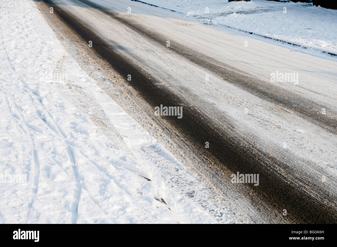 Tyre tracks on an empty road covered in snow and ice Stock Photo - Alamy