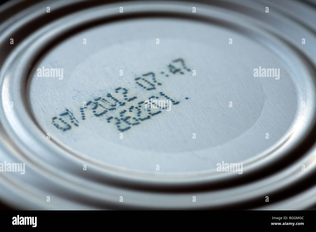 Detail of the base of a food tin showing the manufacturers sell by date, product/ batch code and the pressed metal ring pattern Stock Photo