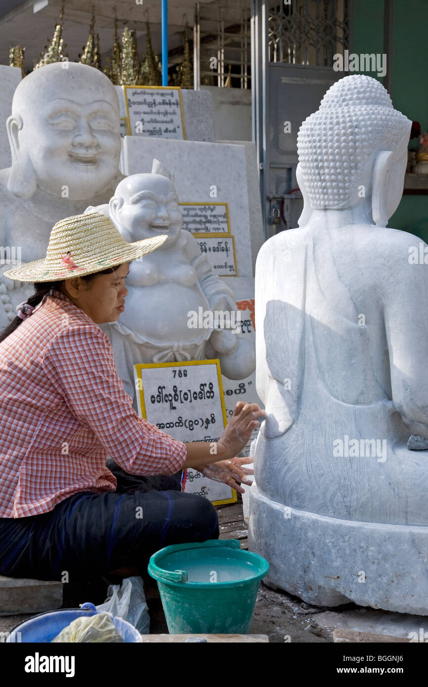 Woman polishing a marble Buddha sculpture. Marble workshop. Mandalay. Myanmar. Stock Photo