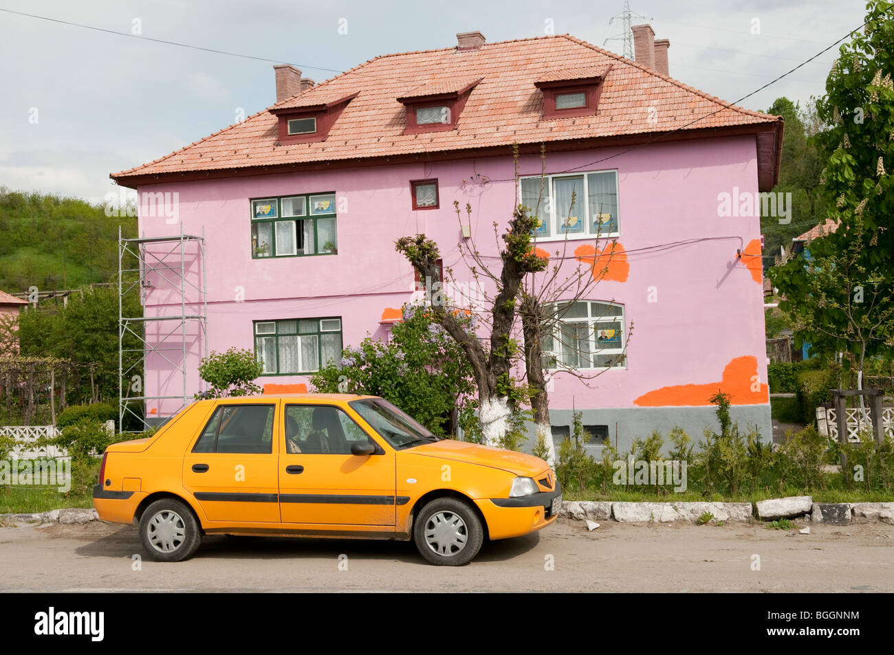 Brightly Painted house in Copsa Mica Romania to try and cover up pollution from the Carbosin Factory Stock Photo