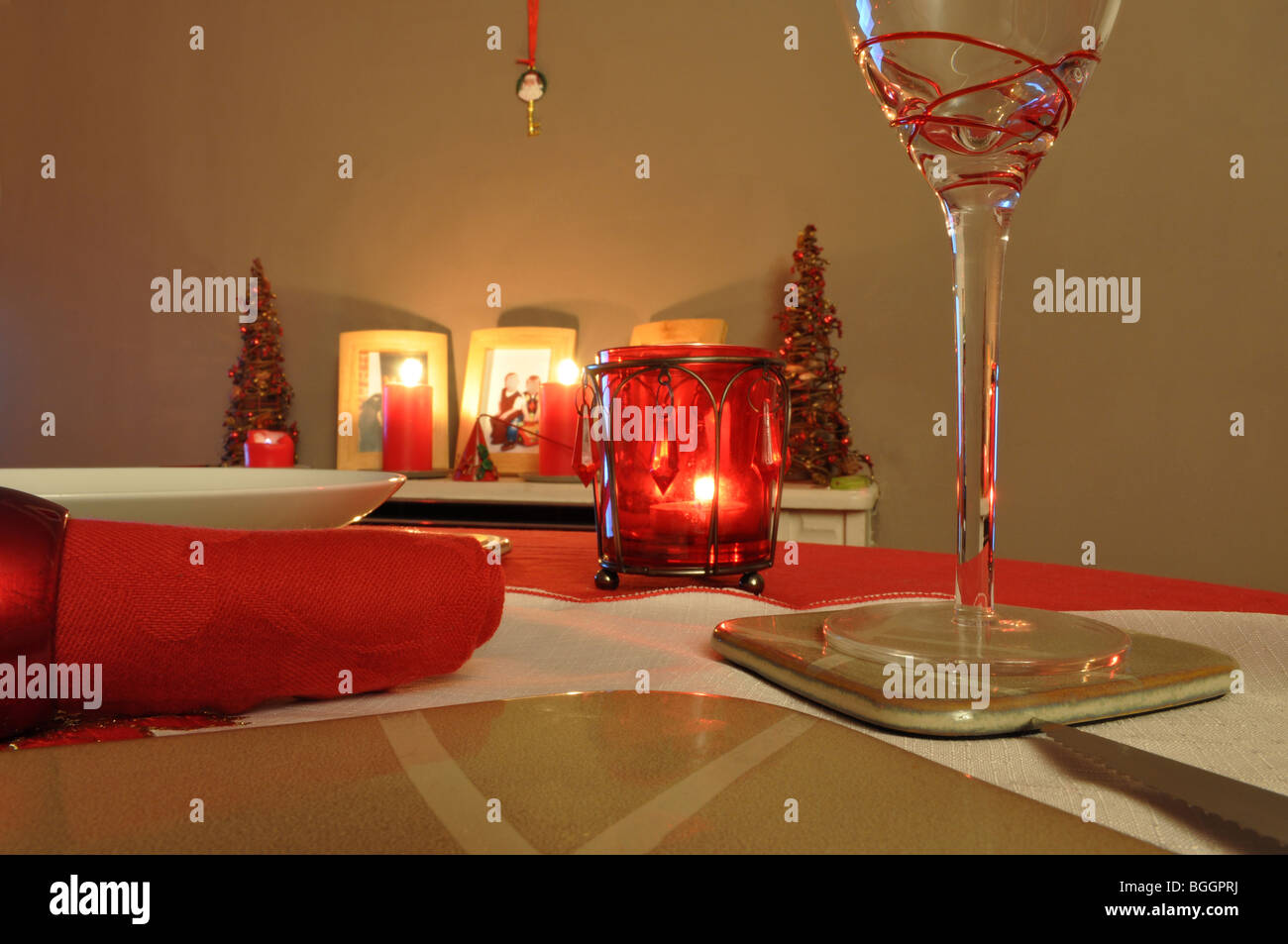 Christmas dinner table with red settings and napkins and wine glass Stock Photo
