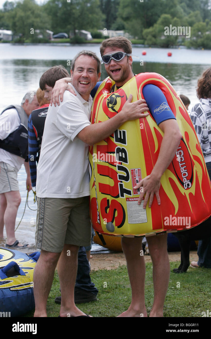 Two men laughing one wearing a water sport  inflatable and eye protectors Stock Photo