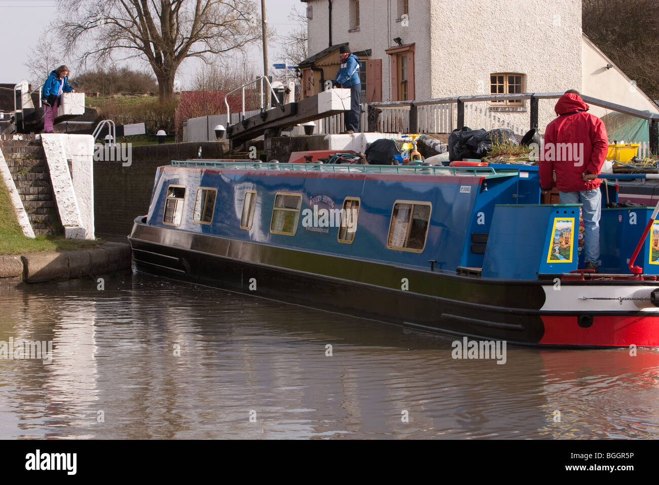 A canal boat entering one of three locks on the Grand Union Canal at Soulbury in Buckinghamshire Stock Photo