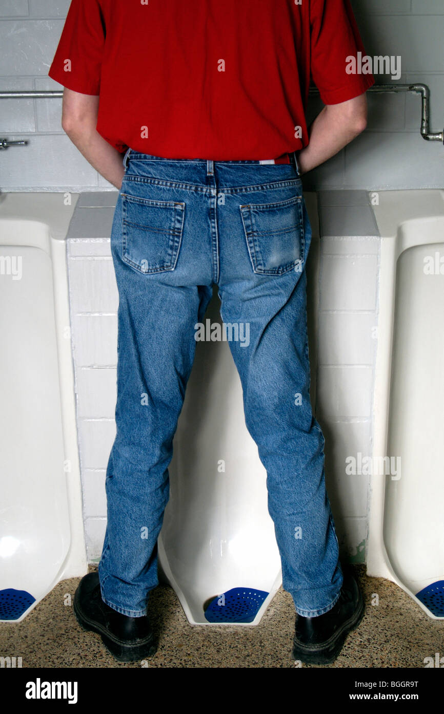 Male standing at urinals Stock Photo