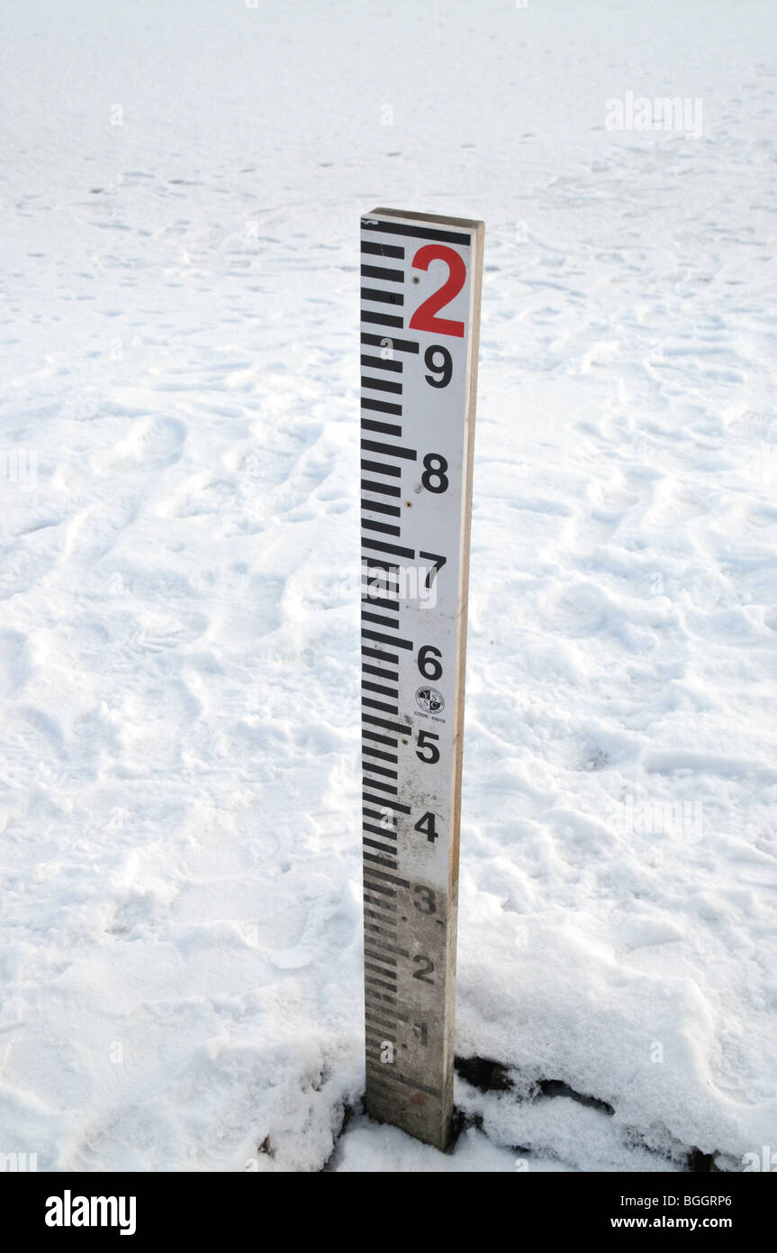 A frozen and snowy lake with a water measuring indicator Stock Photo ...