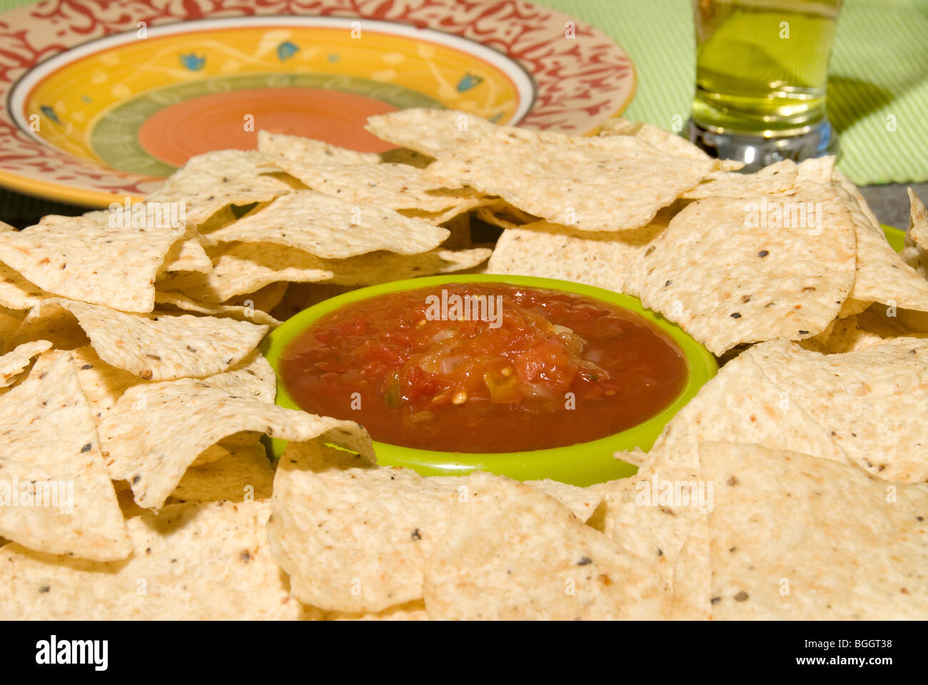 A place setting of tortilla chips with a Mexican style plate waiting to be loaded with snack food Stock Photo