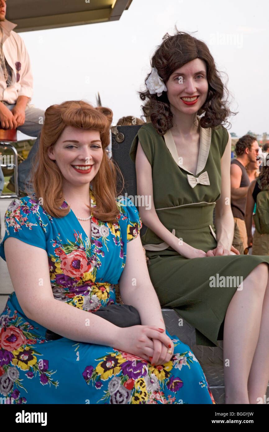 Two women smile as they are dressed in World War II 1940s vintage dresses at Mid-Atlantic Air Museum World War II Weekend Stock Photo