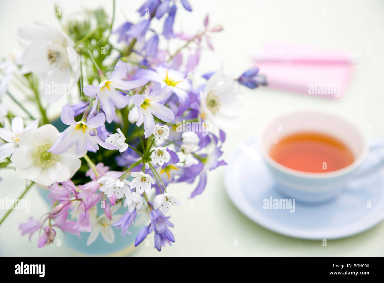 Cup of tea and bunch of flowers Stock Photo