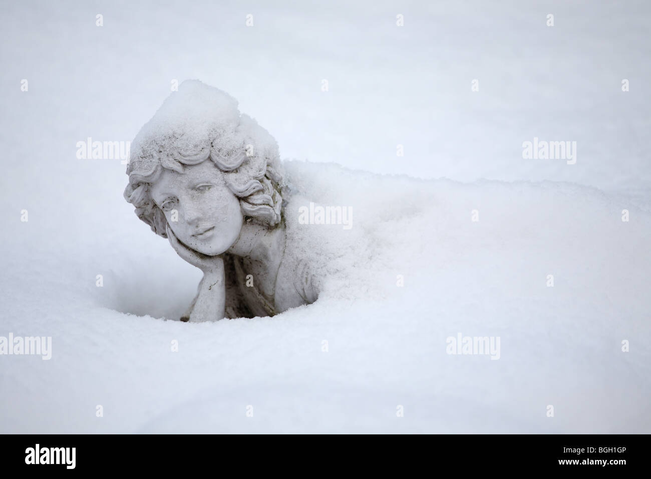Female statue largely covered with snow Stock Photo