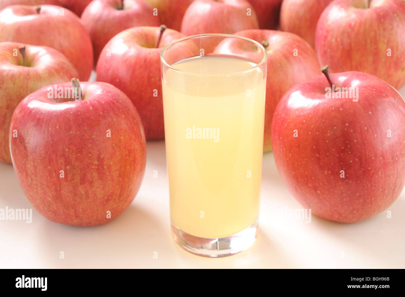 Glass of apple juice amongst apples Stock Photo