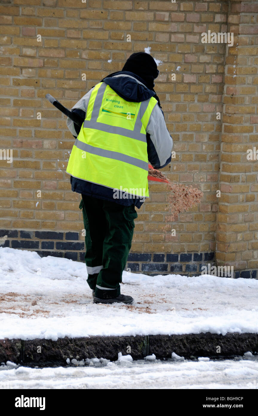 Man gritting the pavement Highbury London England UK Stock Photo