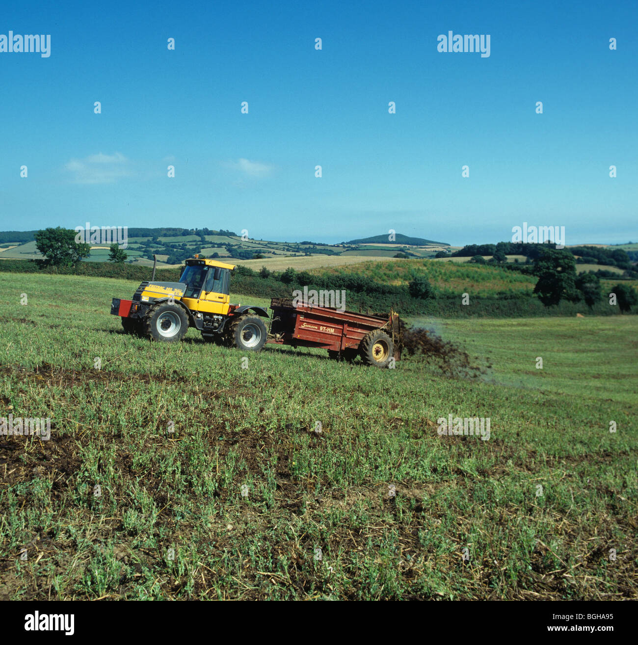 Fastrac tractor spreading manure from a dairy herd onto an uncultivated