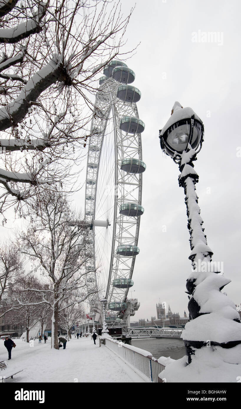 The London Eye on the South Bank in the snow, view towards Houses of Parliament and Westminster Bridge Stock Photo
