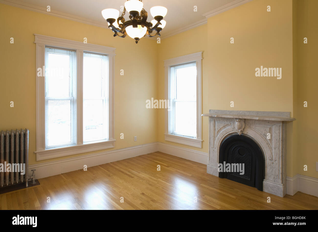 Empty room in apartment with hardwood floor and heater Stock Photo