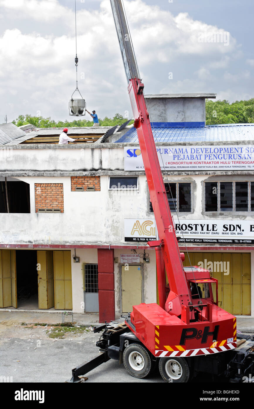 A crane lifting a bucket of cement over a building Stock Photo Alamy