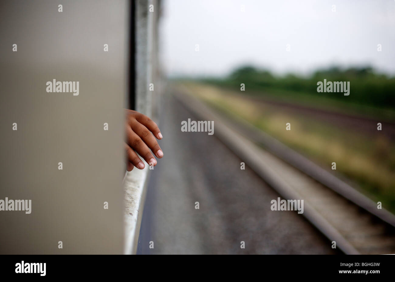 A hand in the window of a train in motion in Thailand Stock Photo