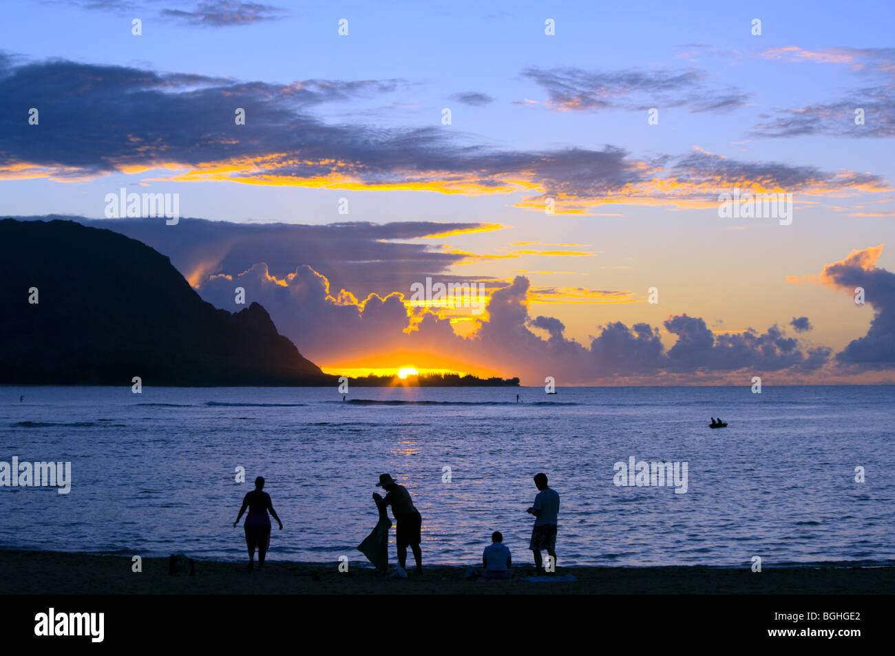 Family preparing to leave Puu Poa Beach Hanalei Bay Kauai HI at sunset Stock Photo
