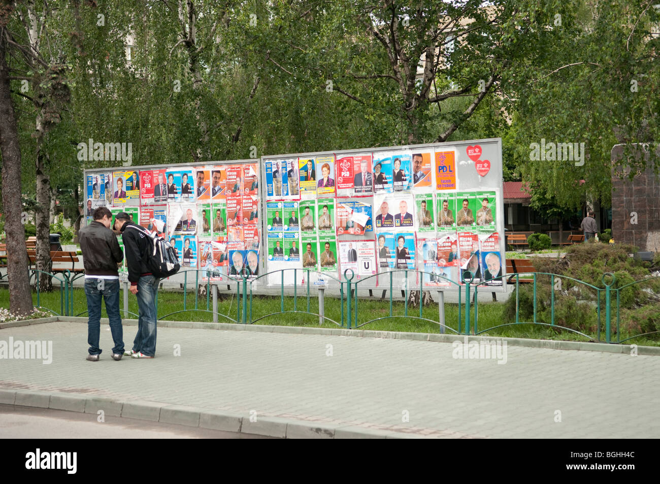 Two Romanians pause by election advertising posters in Ploiesti Romania Eastern Europe Stock Photo