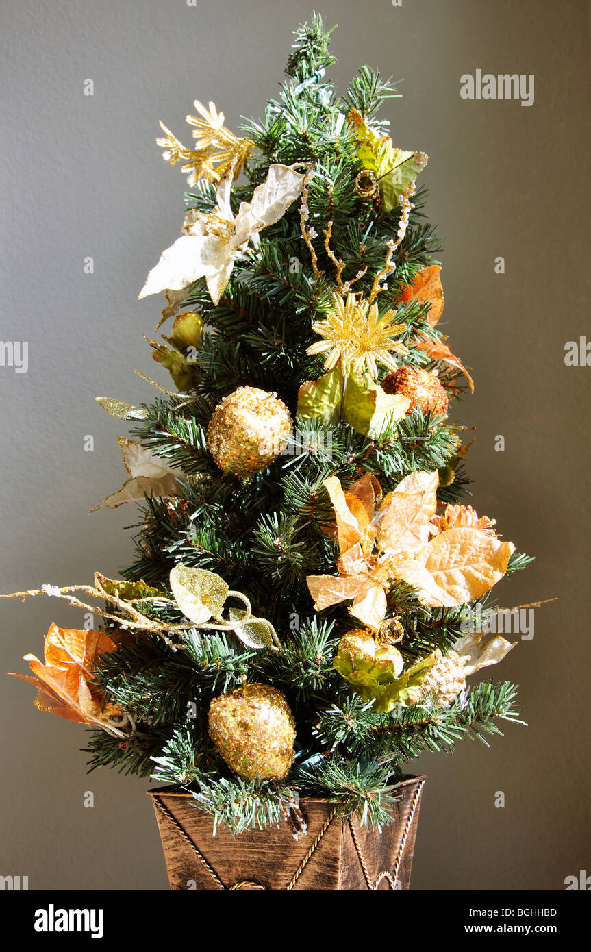 Miniature Christmas tree with golden ornaments Stock Photo
