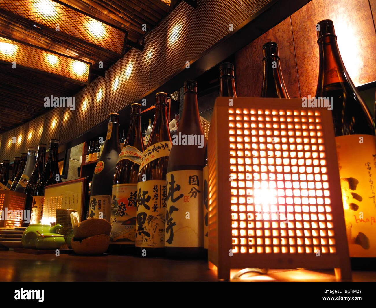 Large Sake bottles displayed on the counter at Sansui Itzakaya bar, Toyko JP Stock Photo