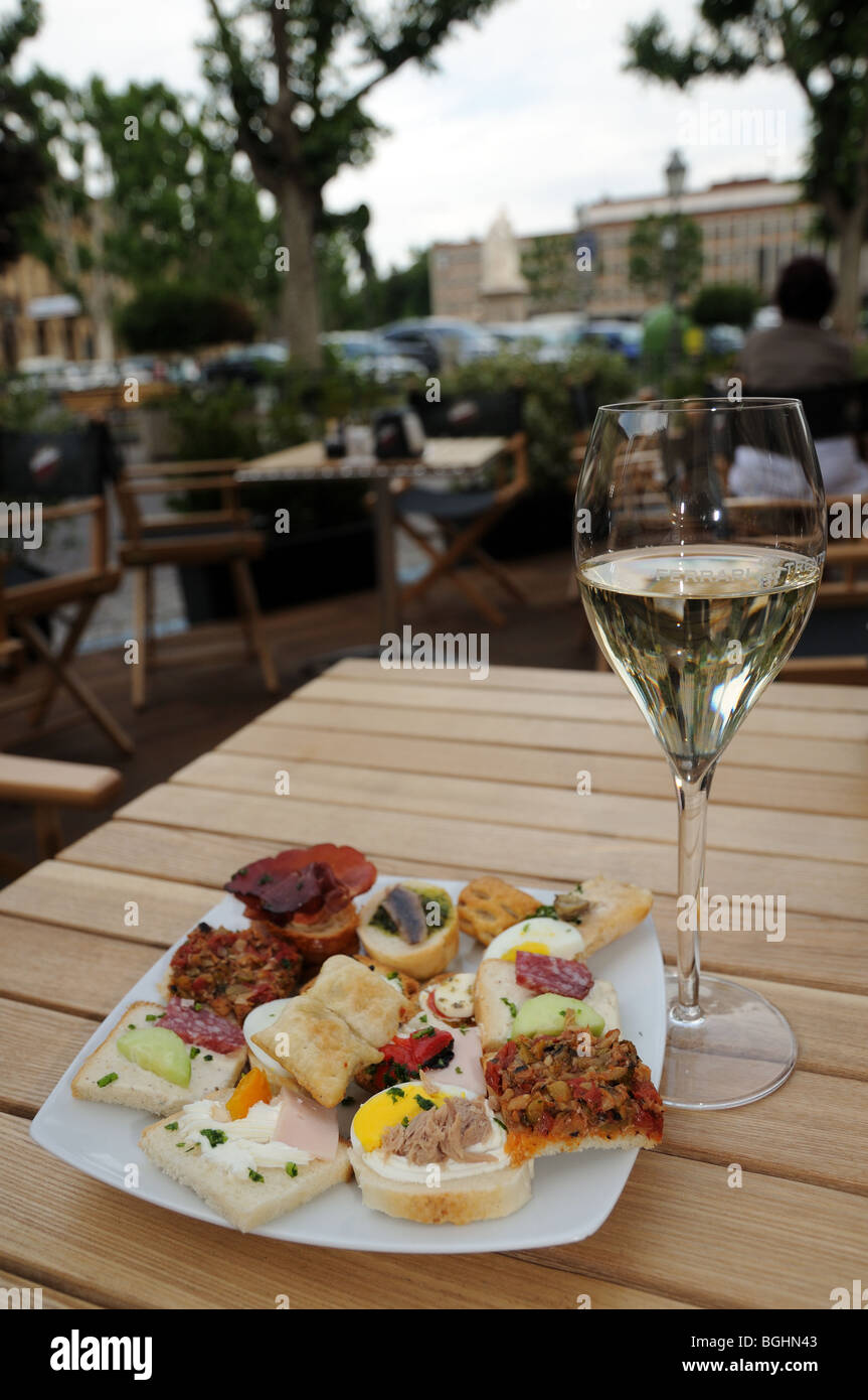 Glass of white wine and generous antipasto hors d’ouvres at bar on Piazza Vittorio Alfieri Asti Piedmont Italy Stock Photo