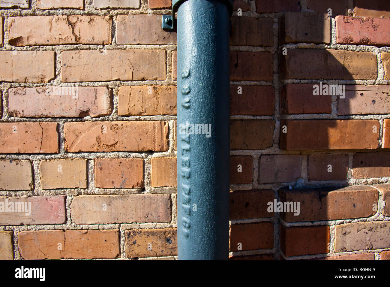 Lead drainage pipe against brick in the French Quarter of New Orleans LA Stock Photo