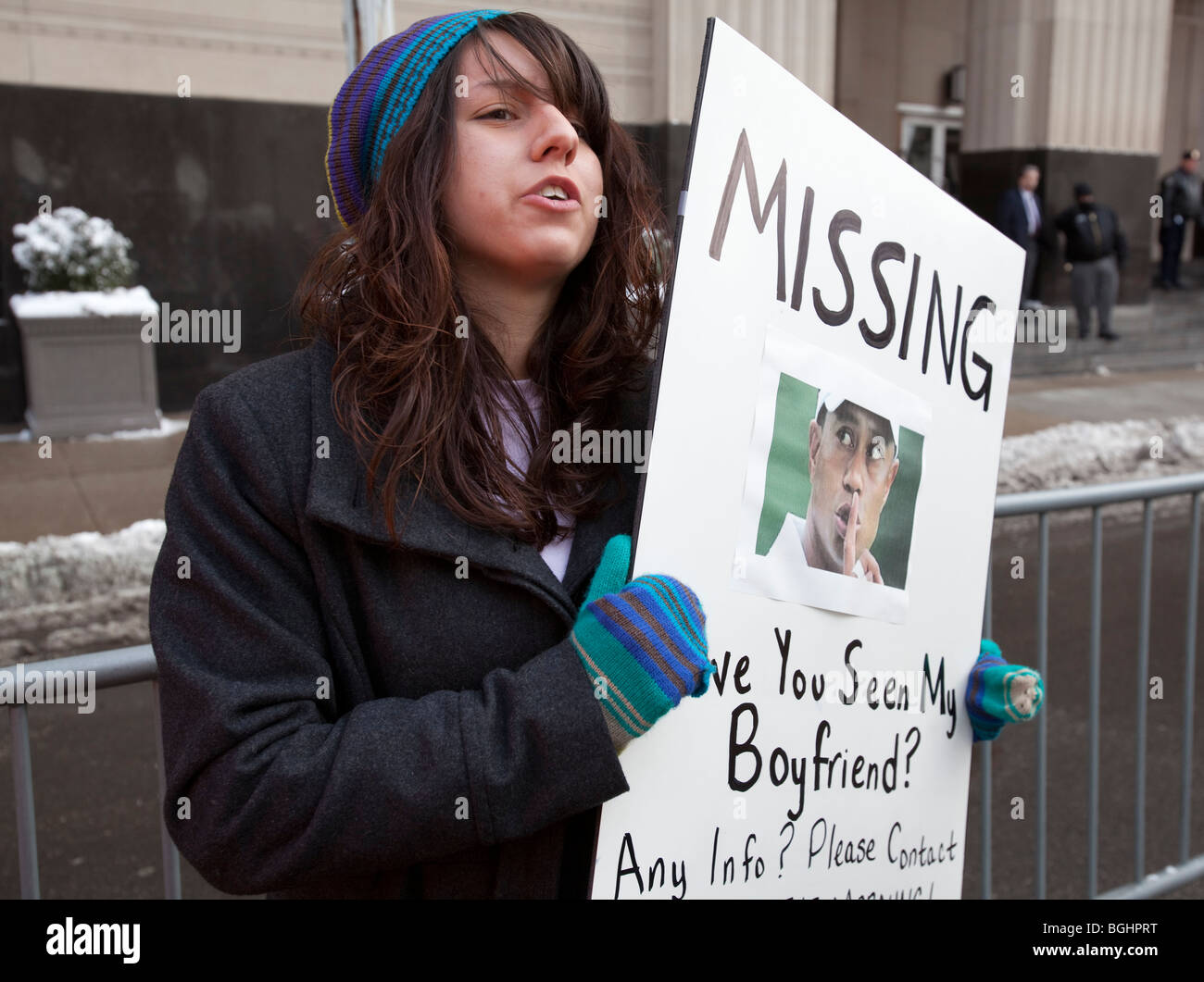 A girl holds a poster claiming that Tiger Woods is her missing boyfriend. Stock Photo