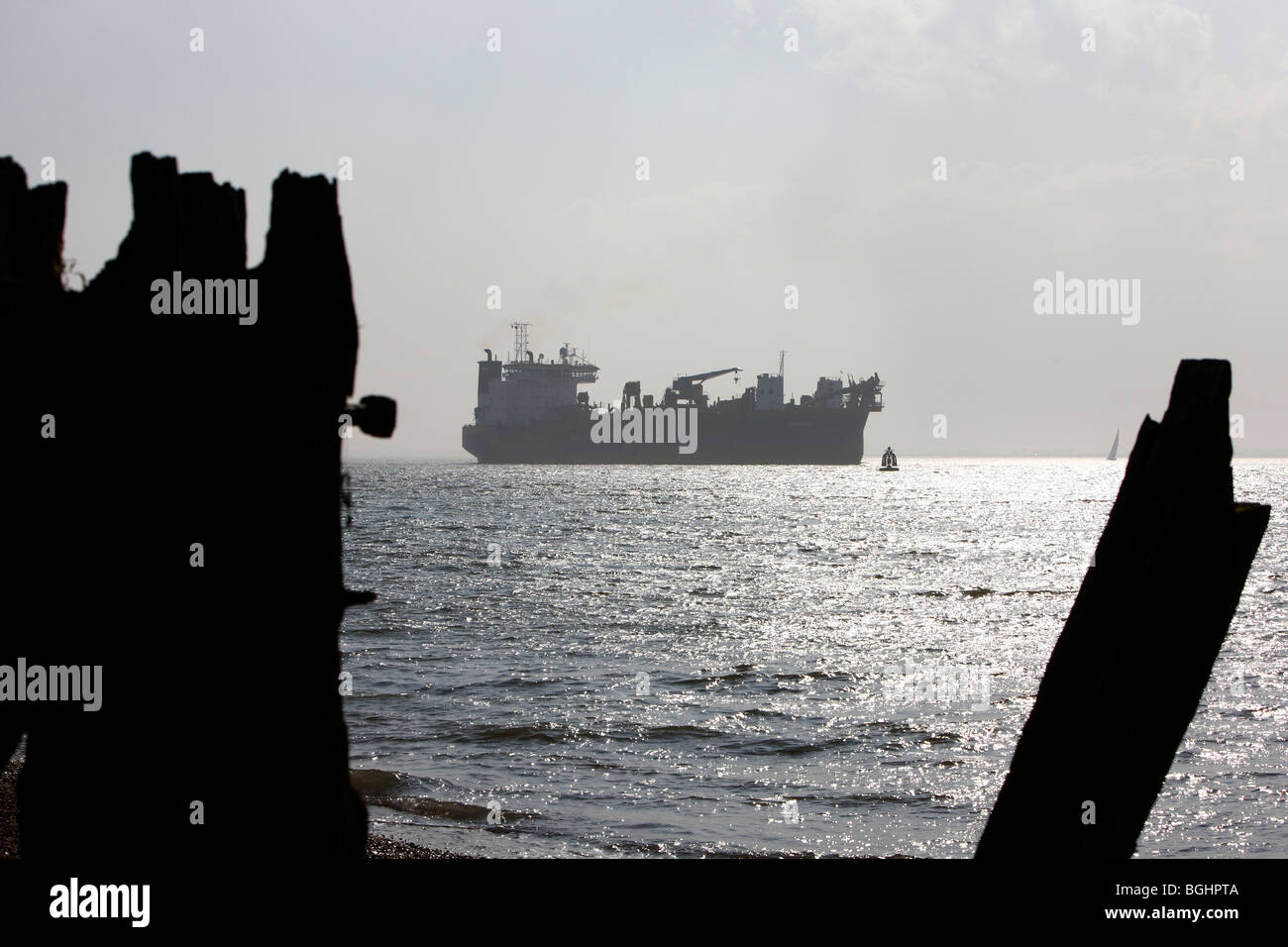 Cargo Container Ship Stumps of old piers Stock Photo - Alamy