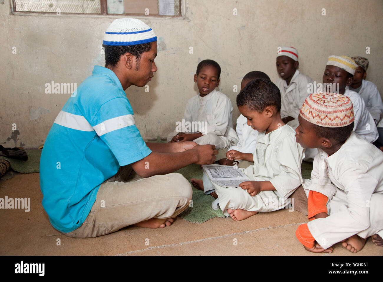 Zanzibar, Tanzania. Imam in a Madrassa (Koranic School) Teaching Young Boy to Read Letters of the Arabic Alphabet. Stock Photo